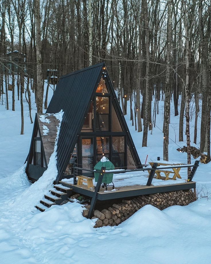 a small cabin in the woods with snow on the ground