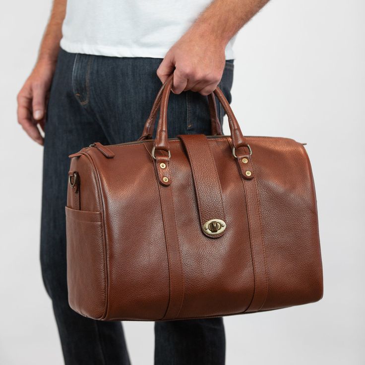 Elevate your carry-on with our newest bag the Travel Duffle. A bag that gets you anywhere you need to go, from the conference room to a weekend retreat, packing everything you need in style. Handcrafted in full-grain leather with antique brass hardware and storage compartments both inside and out. Complete with zipper closure, top strap buckle accent, smooth and sturdy handles, and removable crossbody strap. Details Double top handles Adjustable 54" crossbody strap Zipper and front clasp closure Elegant Travel Satchel With Brass Hardware, Classic Leather Briefcase For Travel, Classic Leather Satchel For Travel, Luxury Brown Satchel With Brass Hardware, Luxury Cognac Bag With Brass Hardware, Classic Satchel Travel Bag For Trips, Classic Travel Accessories With Leather Handles For Daily Use, Classic Leather Travel Accessories With Luggage Sleeve, Classic Leather Weekender Bag For Trips