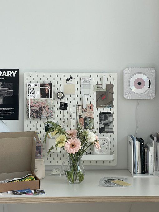 a white desk topped with a vase filled with flowers