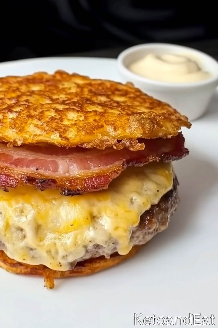 a close up of a sandwich on a plate near a bowl of mayonnaise