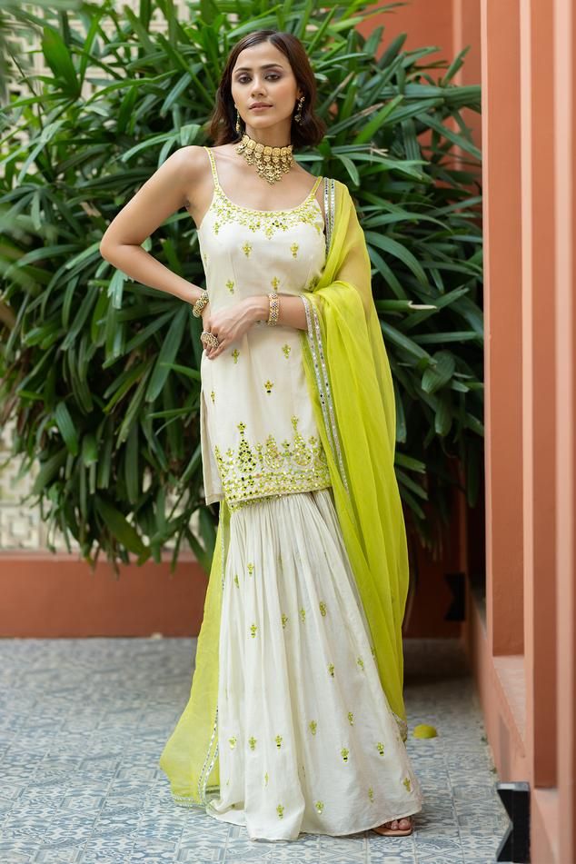 Off-white and green padded kurta with mirror embroidery. Comes with sharara and a dupatta.
Components: 3
Pattern: Embroidered
Type Of Work: Mirror
Neckline: Round
Sleeve Type: Sleeveless
Fabric: Chanderi, Semi crepe, Organza, Lining: Semi crepe
Color: Off White, Green
Other Details: 
Attached lining
Product Weight: 1 Kg
Model Height: 5ft 9inches, wearing size S
Occasion: Sangeet - Aza Fashions Green Indian Suit, Lime Green Lehenga, Mirror Detail, Kurta Sharara Set, Chanderi Dupatta, Kurta Sharara, Mirror Round, Vacuum Storage, Indian Wedding Wear