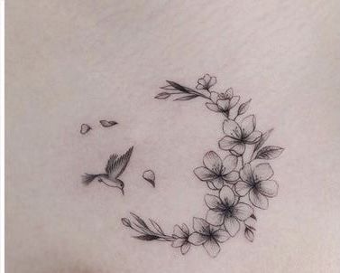 a woman's stomach with flowers and a bird flying in the sky above it