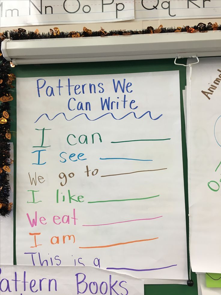 two children's handwritten books are displayed on the wall in front of their classroom