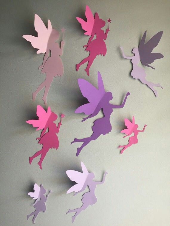 paper cut outs of fairy tinkerbells hanging on the wall