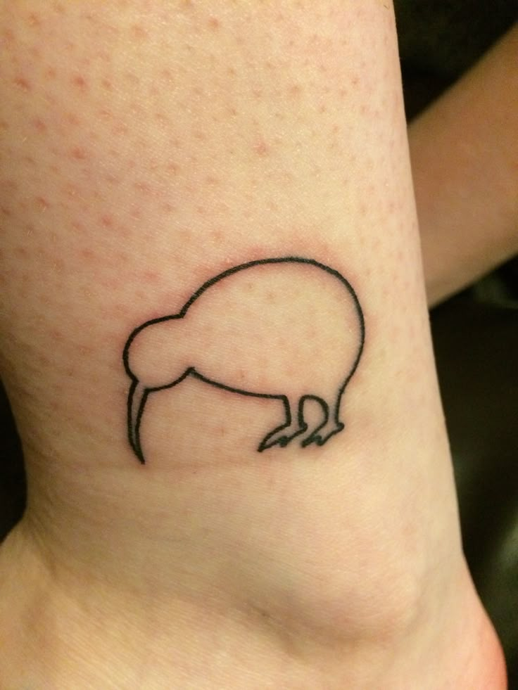 a small black and white animal tattoo on the ankle