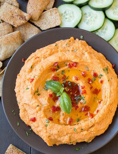 hummus, cucumbers and crackers on a plate