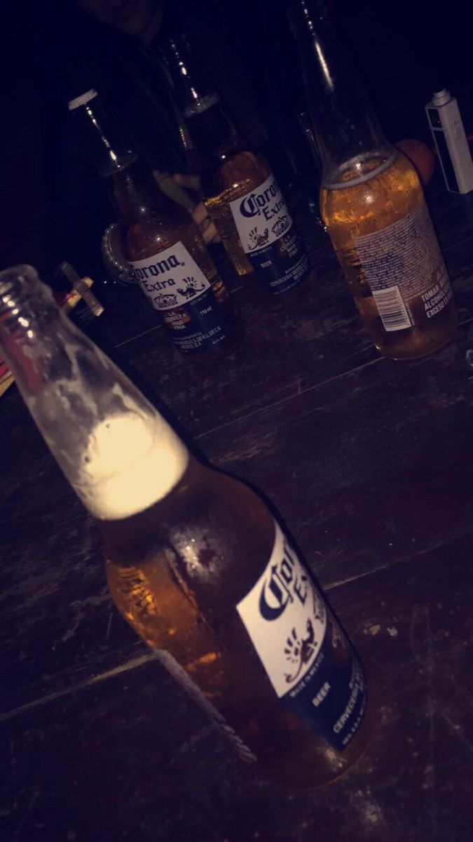 several bottles of beer sitting on a table with one empty bottle in the foreground