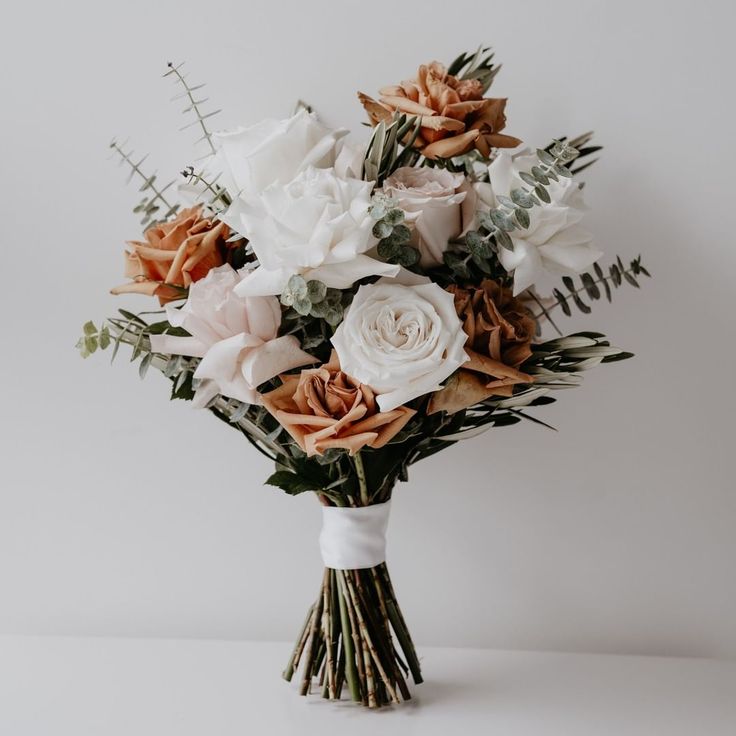 a bouquet of flowers sitting on top of a white table next to a sign that says articfox weddings brides estate