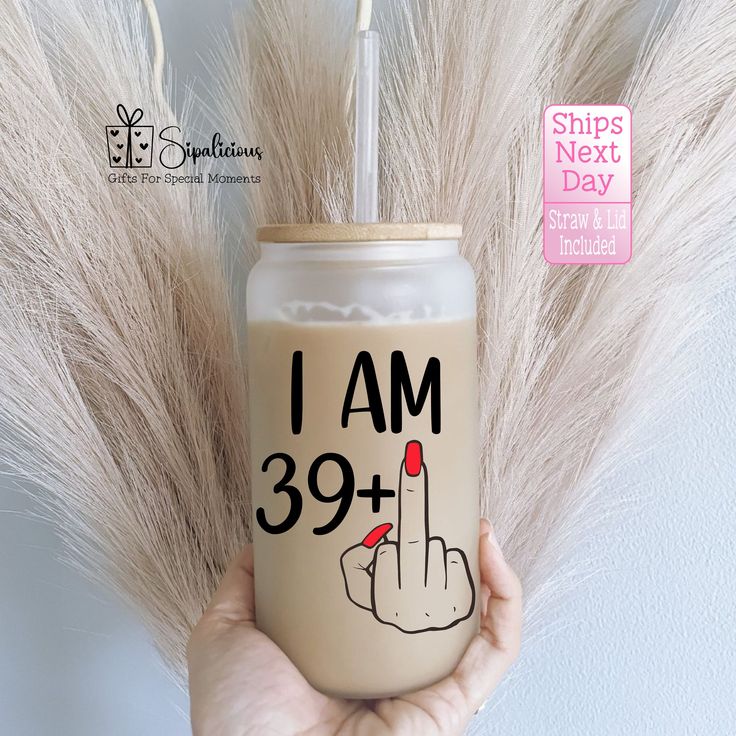 a person holding up a drink with the words i am 39 plus on it and an image of a hand that is pointing down