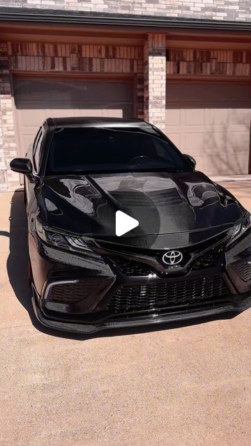 a black car parked in front of a garage