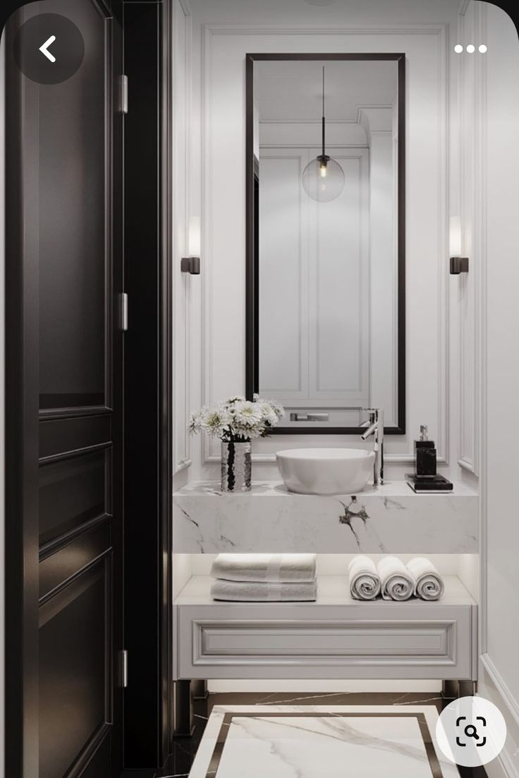 a bathroom with marble counter tops and white walls, along with black trimmings