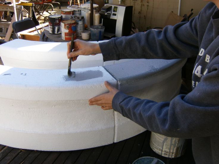 a man is using a large knife to cut something out of the top of a round object