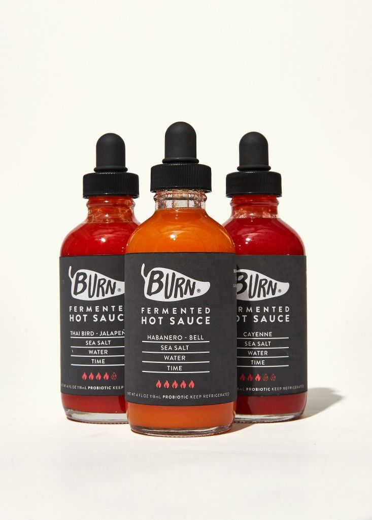 three bottles of burnt hot sauce on a white background