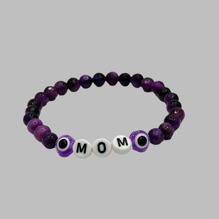 Celebrate the special bond between mother and child with our Mother's Day Bracelet! Made with 6mm or 8mm gemstone beads, this bracelet is a perfect way to show your love and appreciation. Give a meaningful gift that will be cherished for years to come. Purple Crystal Bracelet With 8mm Beads As A Gift, Purple Bracelets With 8mm Beads As Gift, Purple Stretch Bracelet With Gemstone Beads As Gift, Amethyst Stretch Bracelet With Round Beads For Gift, Personalized Purple Beaded Bracelet, Purple 8mm Beads Bracelets As Gift, Purple Gemstone Beads Stretch Bracelet As Gift, Personalized Purple Charm Bracelet For Friendship, Evil Eye Bracelet With Letter Beads As Gift