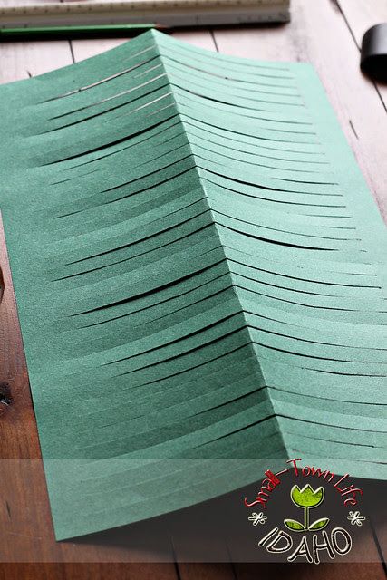 a folded green paper on top of a wooden table