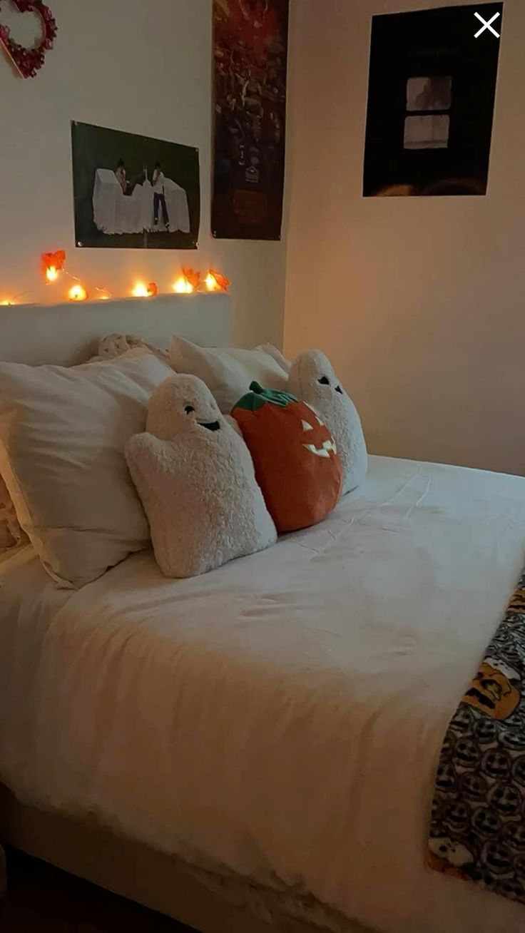 a bed with two stuffed animals sitting on it's pillows in front of the headboard