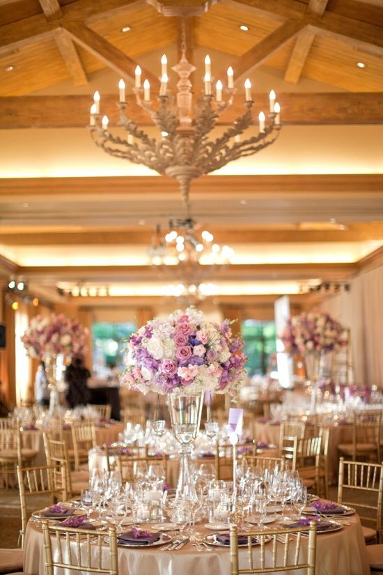 the tables are set with white linens and purple flowers