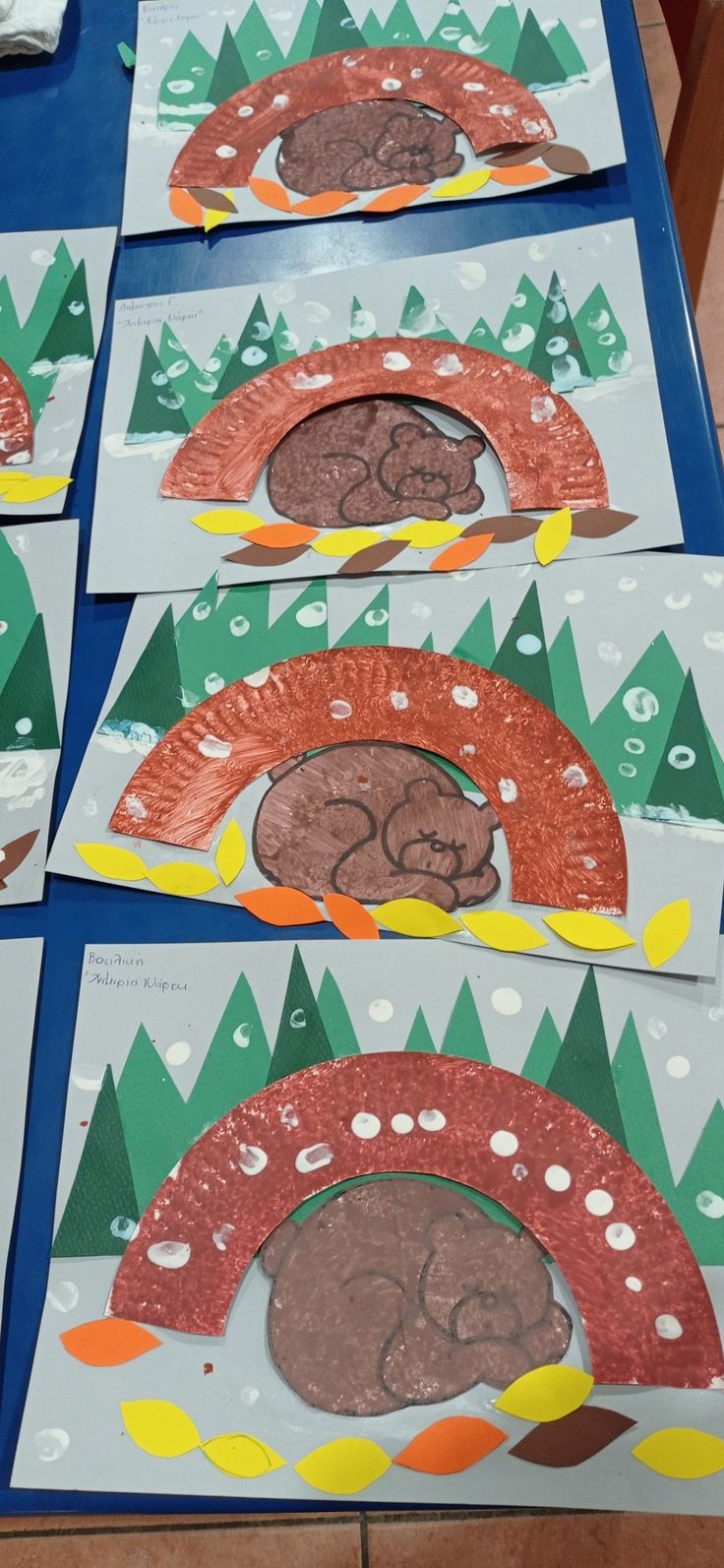 four paper plates with different shapes and sizes of cookies on them, sitting on a blue table