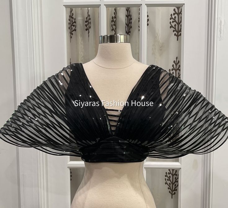 This Beautiful and Elegant Gwen Mettalic finish Blouse is designed exclusively by Siyaras Fashion House. We are sure this Ballon style mettalic blouse will turn heads during any event and once can nicely pair with matching or contrast satin/sequin skirt. The Blouse holds the ballon shape which falls nicely on the side.Fits size: size 36 plus has 4 inches margin. Material: Satin with Net and Metallic finish to give the Ballon Shaped Look. Black Satin Party Blouse, Glamorous Padded Blouse For Evening, Satin V-neck Party Blouse, Glamorous Party Blouse Piece With Sequins, Black Satin Tops For Party, Party Satin Unstitched Blouse Piece, Festive Satin Blouse Piece For Party, Festive Satin Party Blouse Piece, Party Satin Blouse With Padded Detail