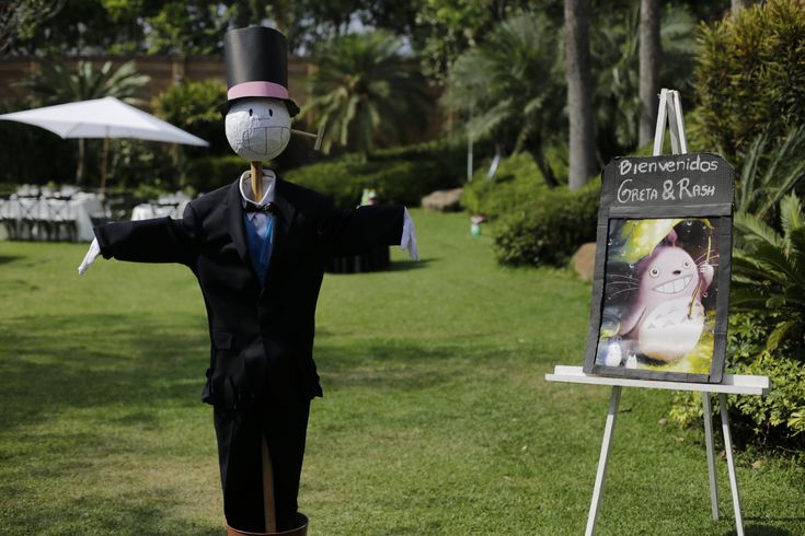 a man in a suit and top hat standing next to a sign with an image on it