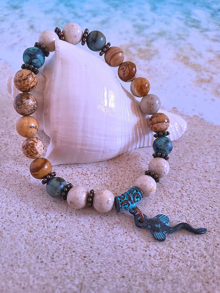 Get those sandy vibes flowing with our Beachy Bracelets, featuring natural stones, patina green accents, pearls, and cute ocean-inspired charms. Our Mykonos Collection would not be complete without some versatile, easy-to-use stretch bracelets. Wear one alone or stack a few for a bold BoHo look. Each bracelet features antiqued patina charms and spacers made in Greece, where the art of metal finishing was popular already thousands of years ago. Pearls, stingrays, shells, and other fun shapes ador Bohemian Gemstone Beads Bracelets For Beach, Bohemian Gemstone Beads Bracelet For Beach, Brown Beaded Bracelets With Natural Stones For Beach, Brown Natural Stones Beaded Bracelets For Beach, Brown Natural Stone Beaded Bracelets For Beach, Earthy Natural Stone Beaded Bracelets For Beach, Bohemian Bracelets With Natural Stones For Beach, Bohemian Beaded Bracelets With Natural Stones For Beach, Spiritual Gemstone Beaded Bracelets For The Beach