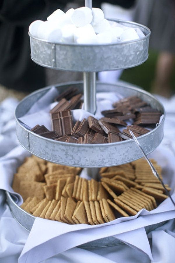 three tiered trays with marshmallows and crackers in them on a table