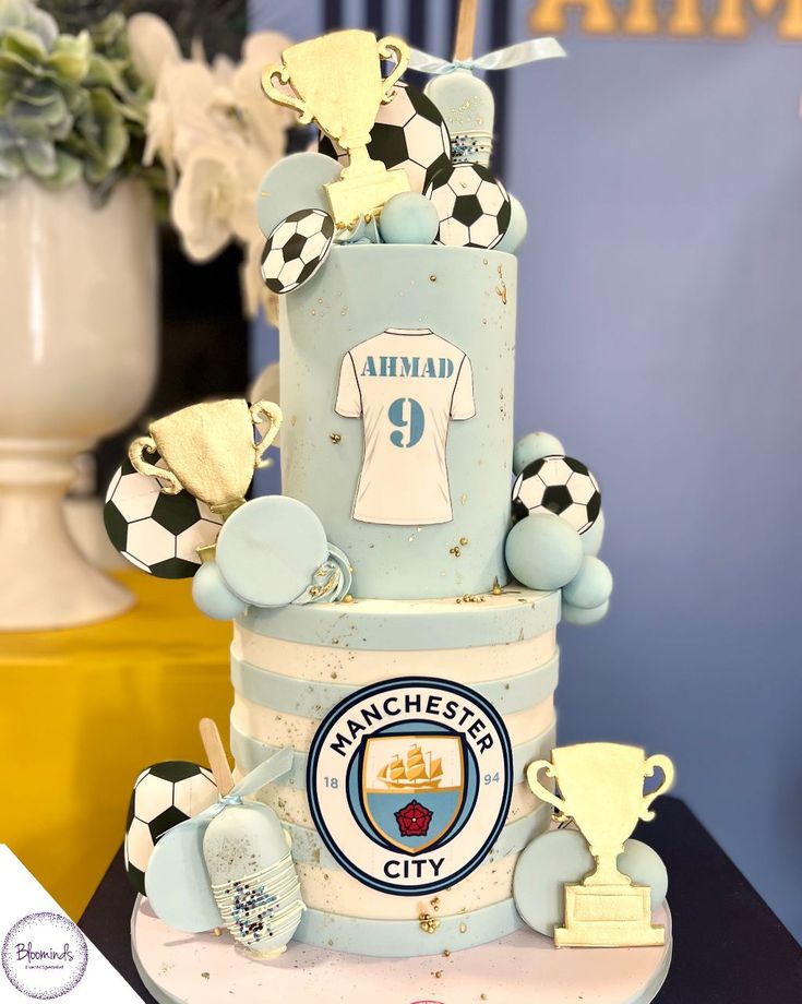 a blue cake with soccer themed decorations on it