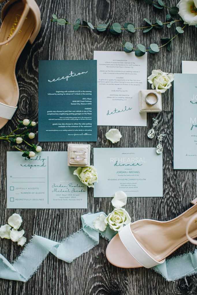 the wedding stationery is laid out on top of the table with shoes and flowers