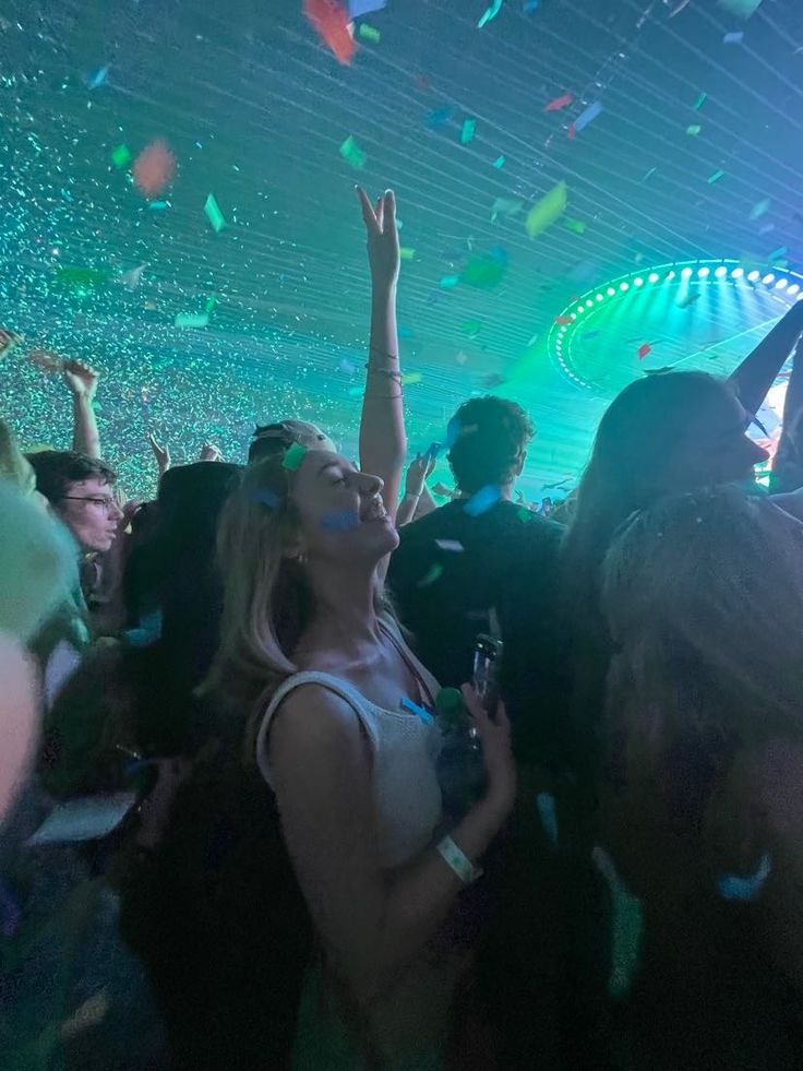 a group of people at a party with confetti falling from the ceiling