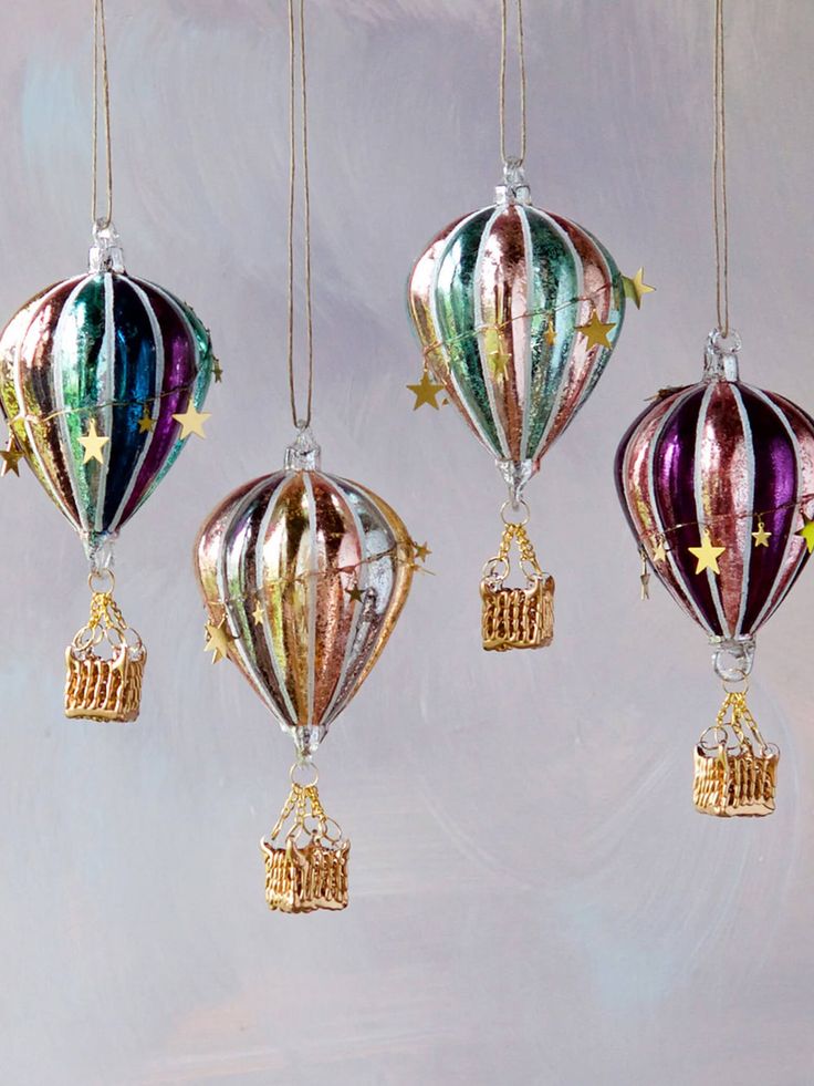 three christmas ornaments hanging from strings in the shape of hot air balloons with stars on them