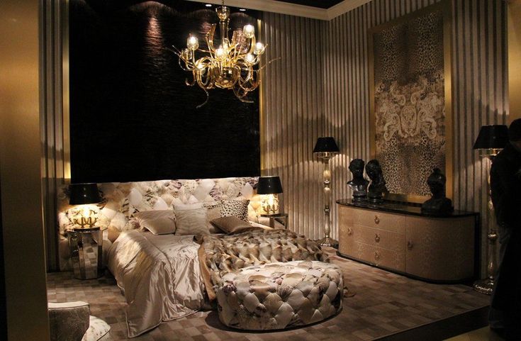 a bed room with a neatly made bed and chandelier