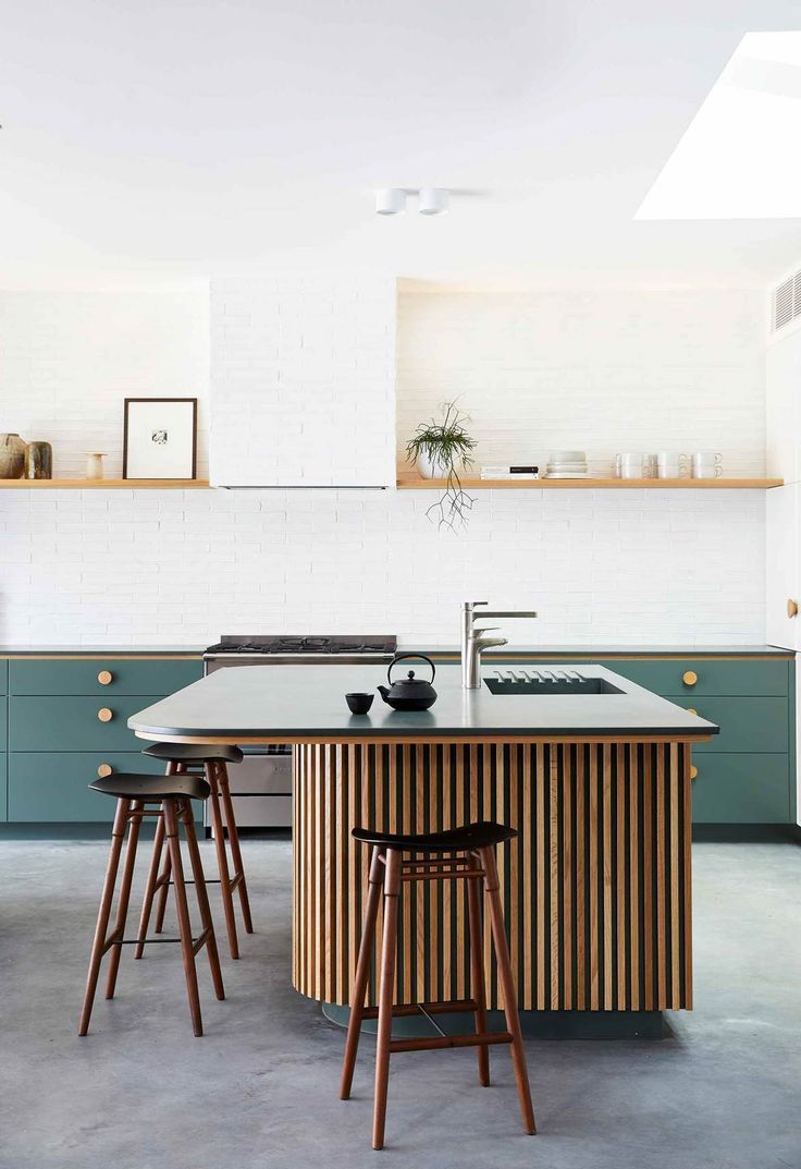 a kitchen island with stools in front of it