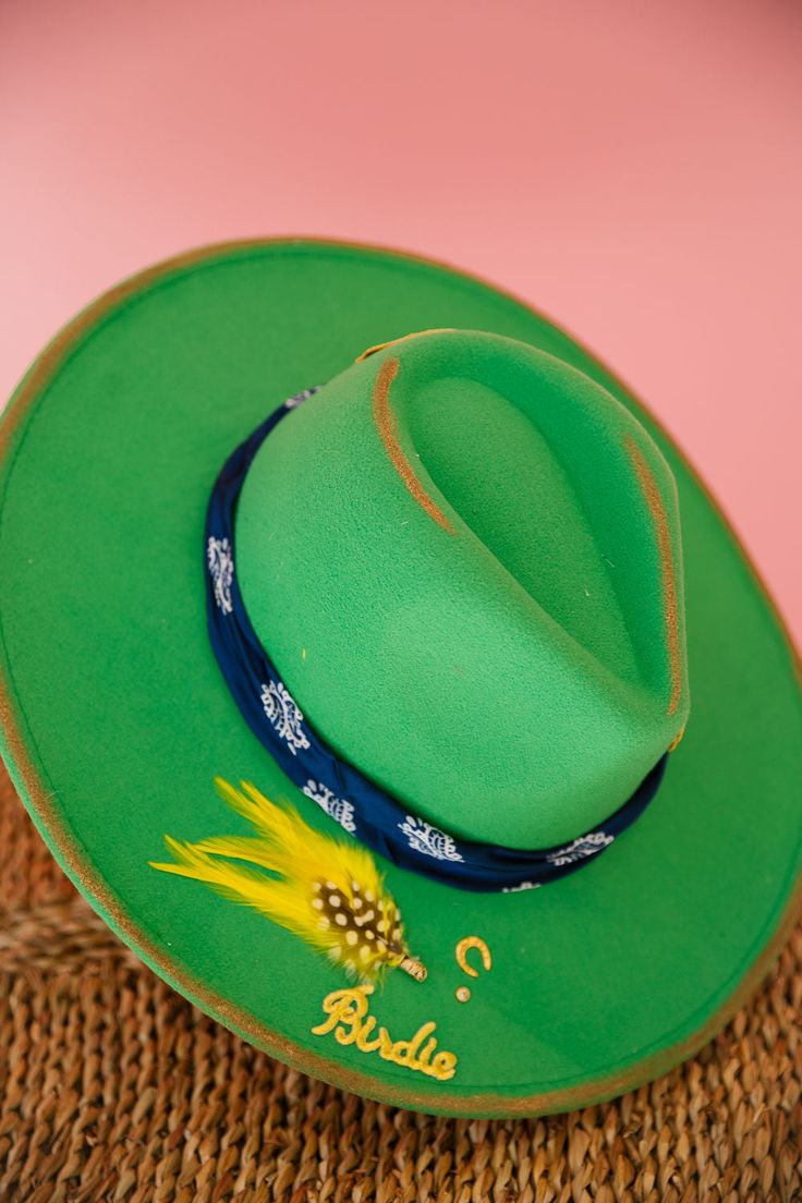 Ready to hit the green in style? Look no further than our ON THE GREENS RANCHER HAT! Made with a green rancher style and adorned with gold accents, a navy bandana ribbon, a gold Golf patch, and gold pins, this unique hat is sure to turn heads on any golf course. Keep the sun out of your eyes while showing off your playful personality. Tee up and add this hat to your golfing arsenal now! This hat is ONE OF A KIND, created by our owner Stephanie. To receive item quicker, expedited shipping is avai Judith March, Rancher Hat, Unique Hats, Suns Out, Gold Pin, Southern Charm, Golf Carts, Golf Course, Arsenal