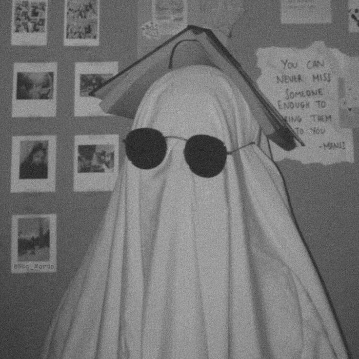 a black and white photo of a ghost with sunglasses on it's head in front of a refrigerator