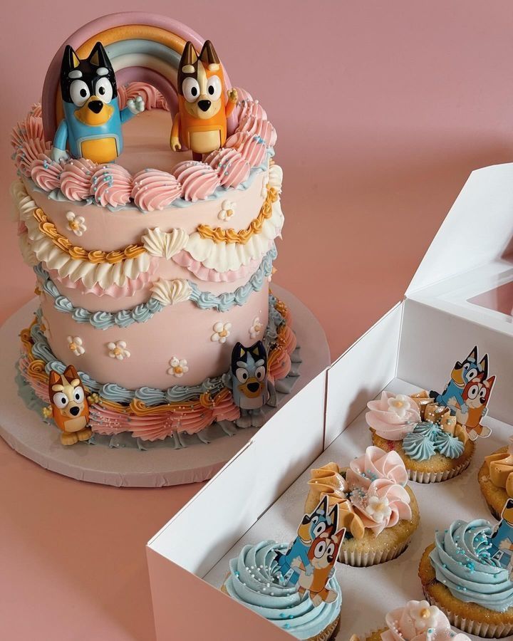 a pink cake and cupcakes with cartoon characters on them