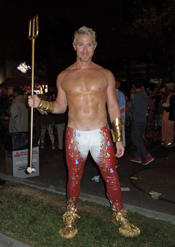 a man dressed up as a gladiator holding a spear and wearing gold gloves