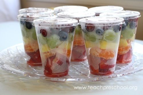 several cups filled with fruit on top of a clear plate and sitting on a table