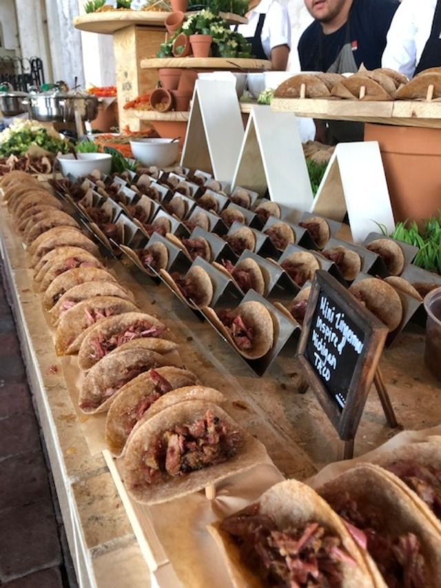 several sandwiches are lined up on a table with people in the background at a food stand