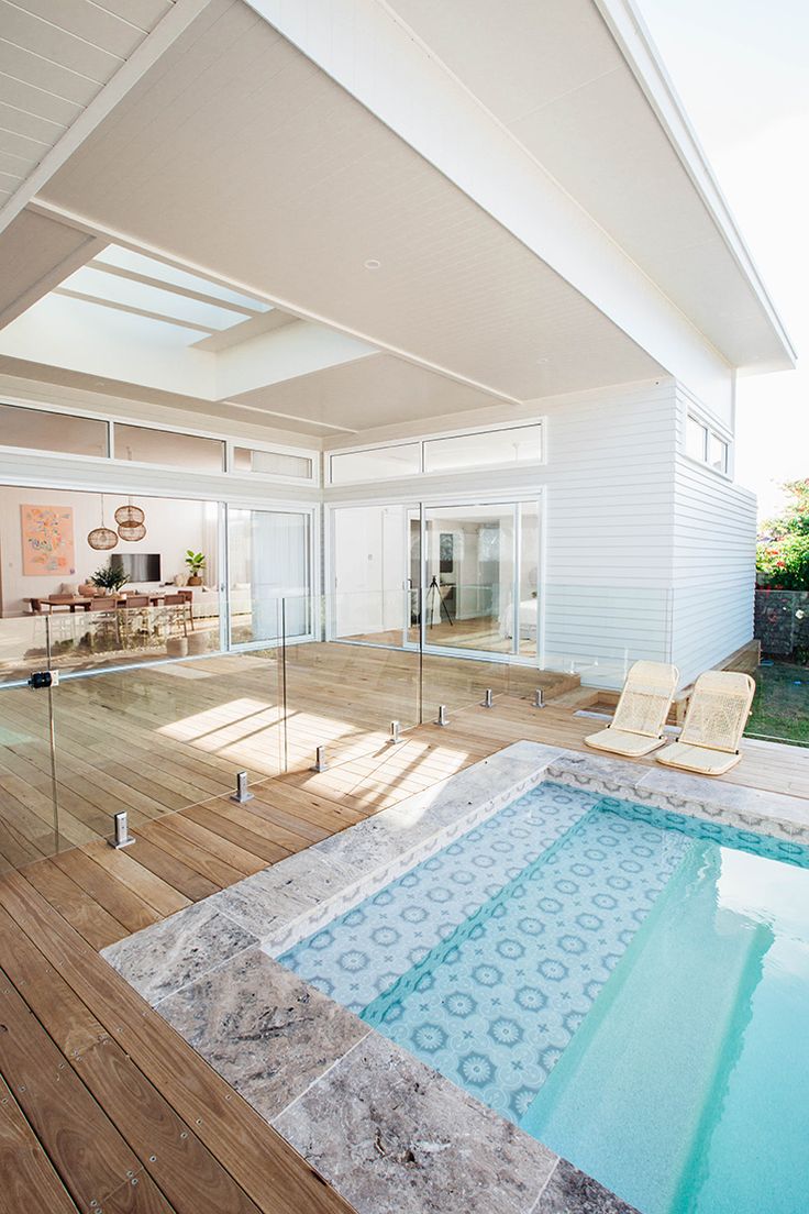 an indoor swimming pool in the middle of a wooden deck