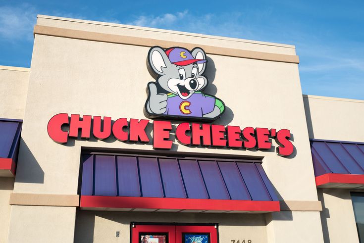 the front of chuck e cheese's restaurant on a sunny day with blue skies in the background