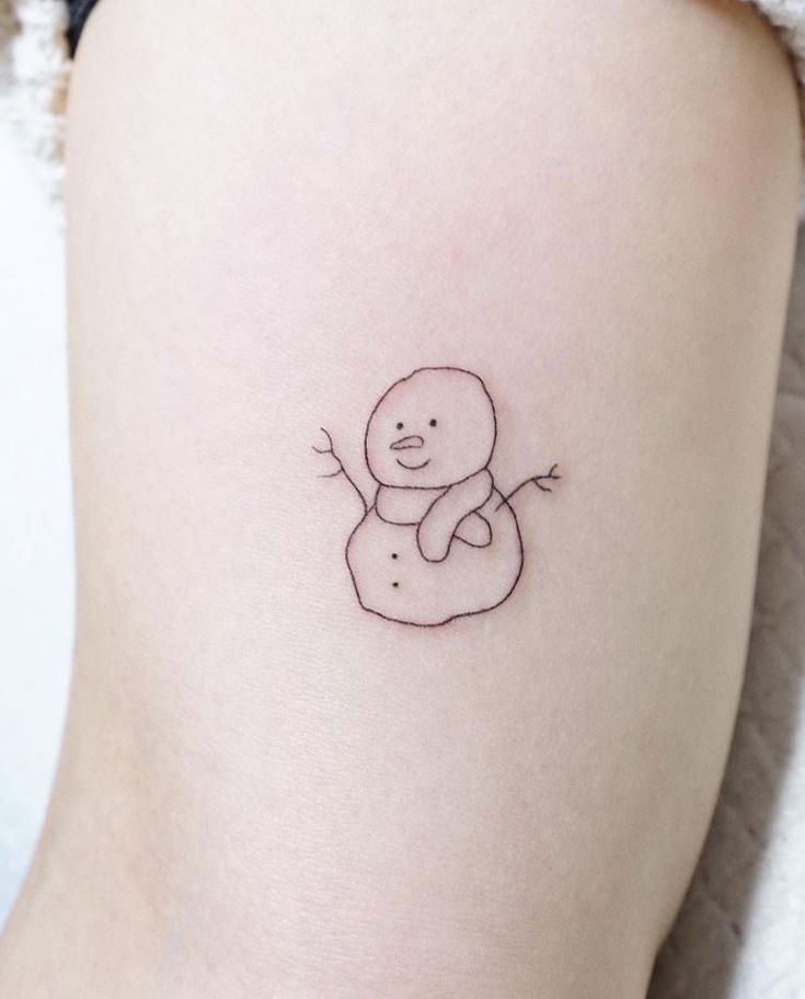 a small tattoo on the thigh of a woman's leg with a drawing of a snowman