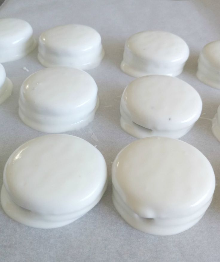 several white donuts sitting on top of a baking sheet