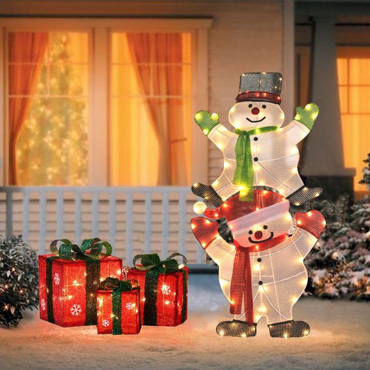 lighted snowman and presents in front of a house