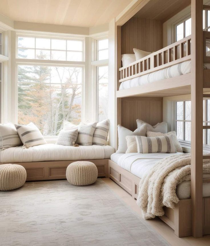 a bedroom with bunk beds and pillows on the bottom floor, along with two couches