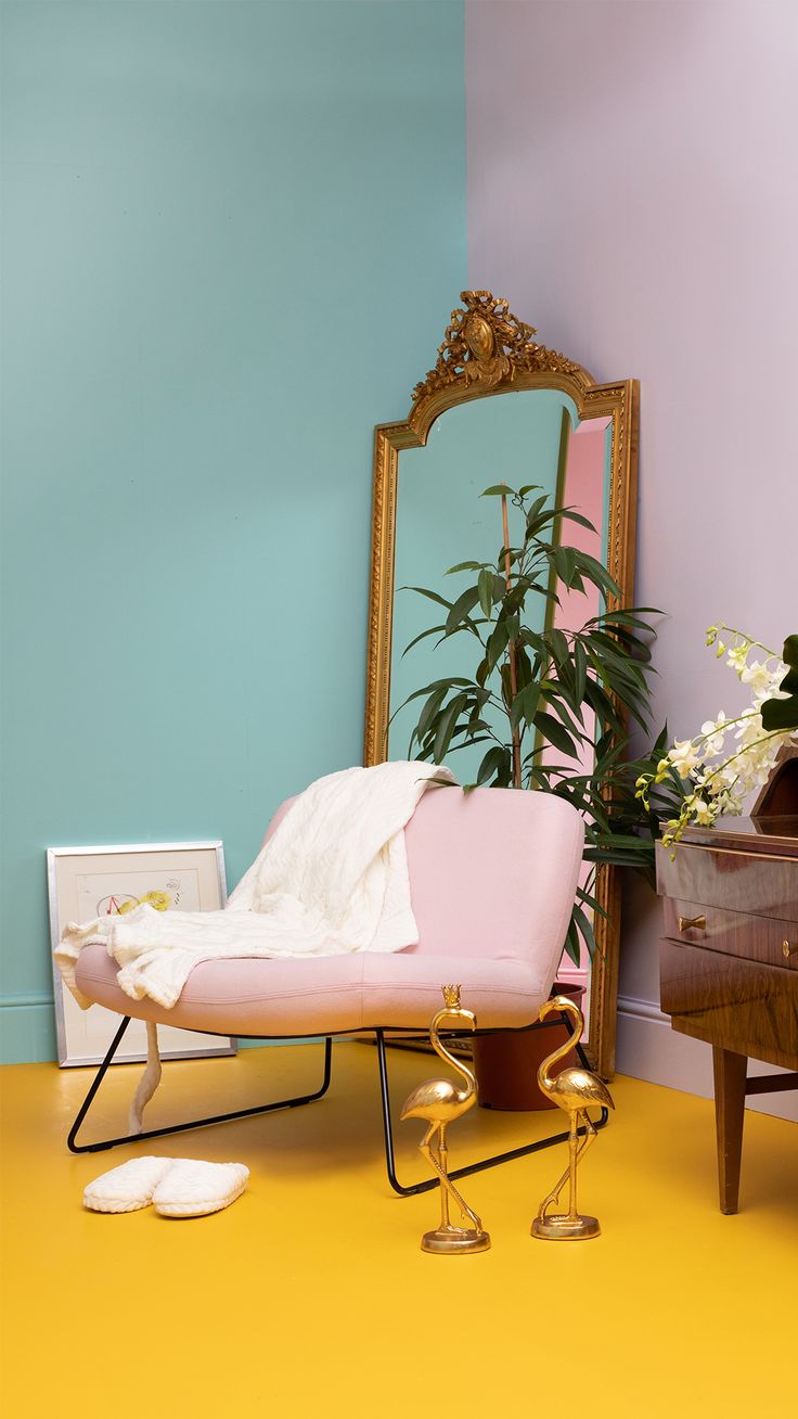 a living room with a couch, mirror and potted plant on the floor in front of it