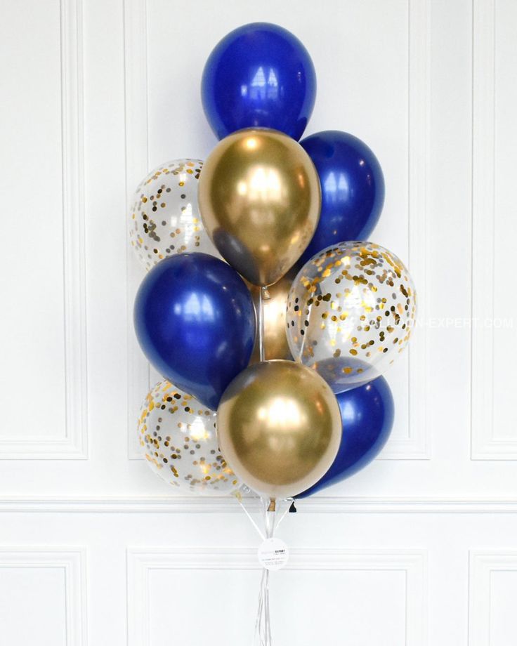 a bunch of blue and gold balloons hanging on the wall