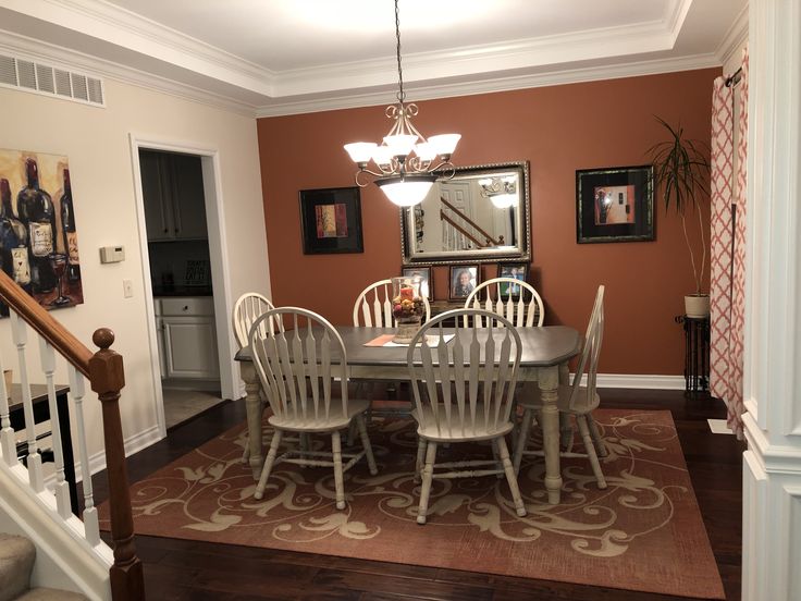 a dinning room table with chairs and a rug on the floor