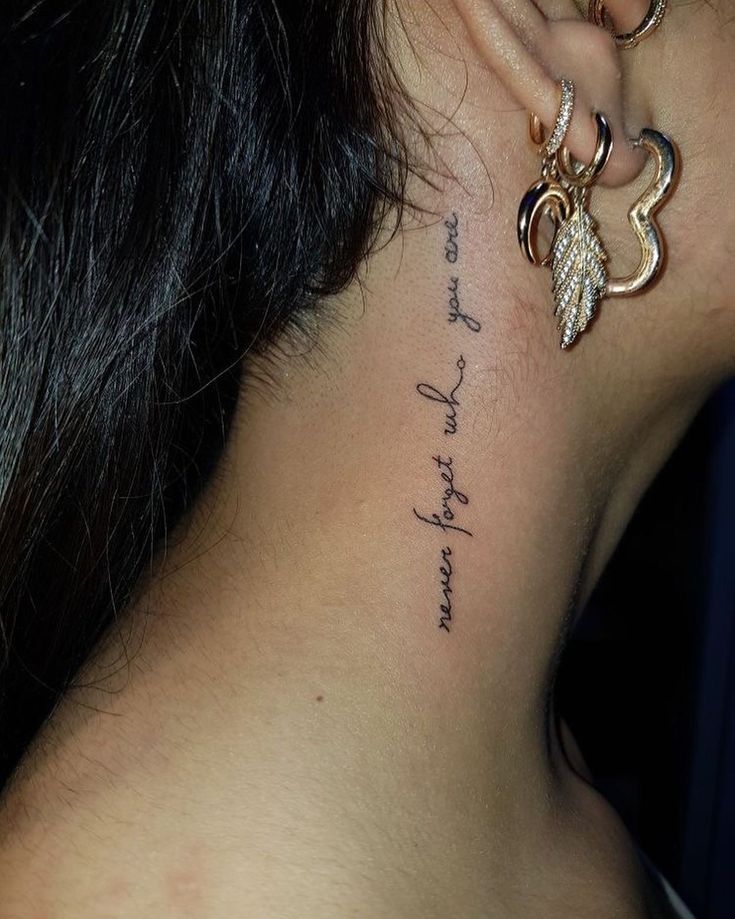 the back of a woman's neck has a tattoo on it