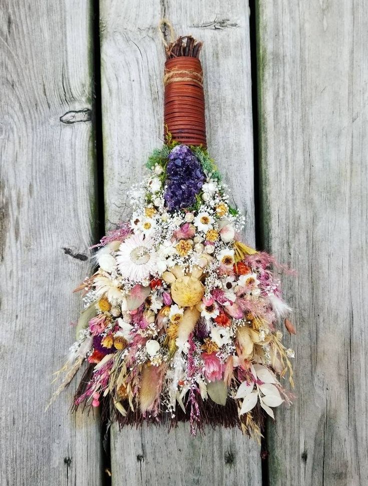 a bunch of flowers that are on the side of a wooden fence and attached to a pole