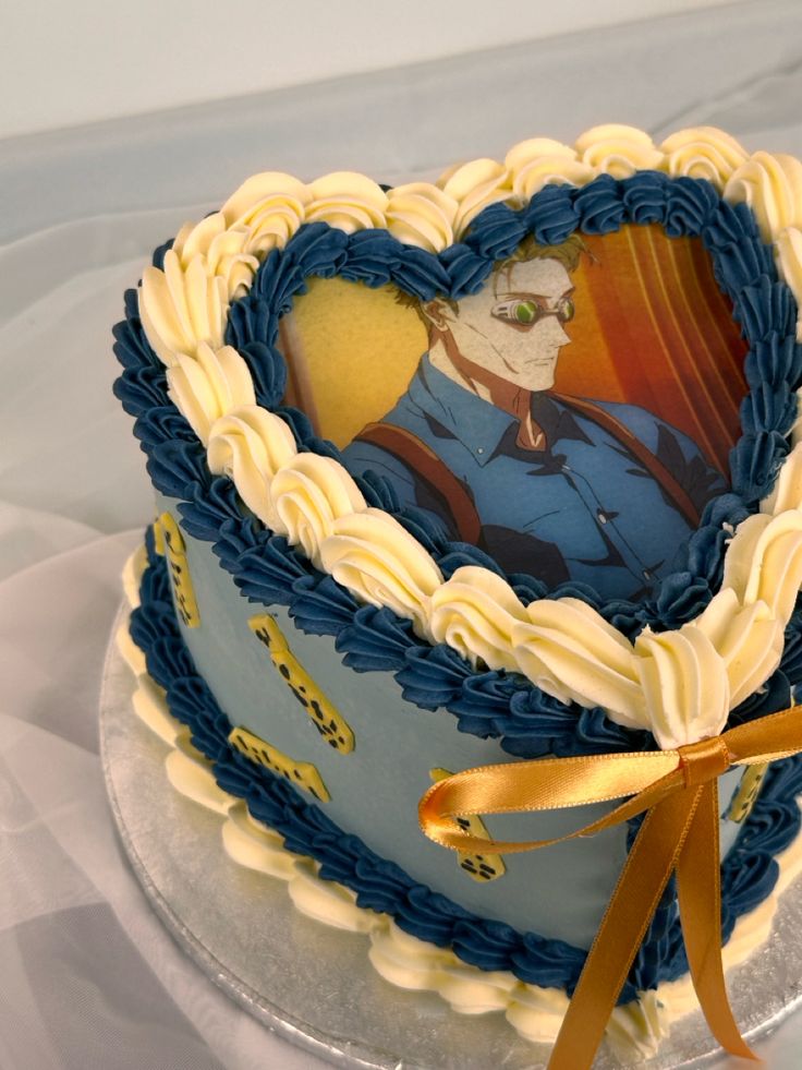 a blue and white cake with an image of a man in the heart on it